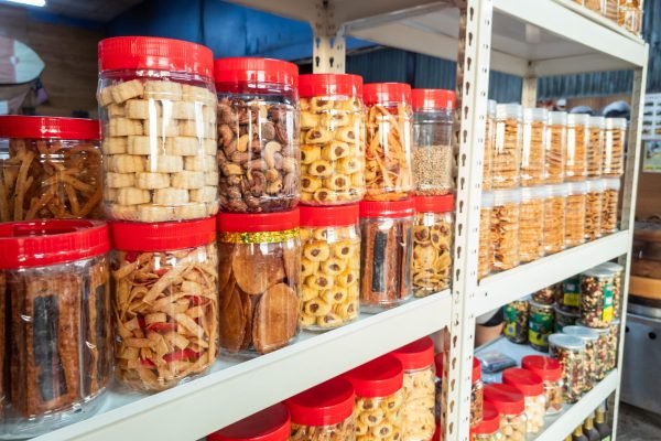 Variety of Chinese New Year cookies in jars place on shelf of retail for sale in Malaysia